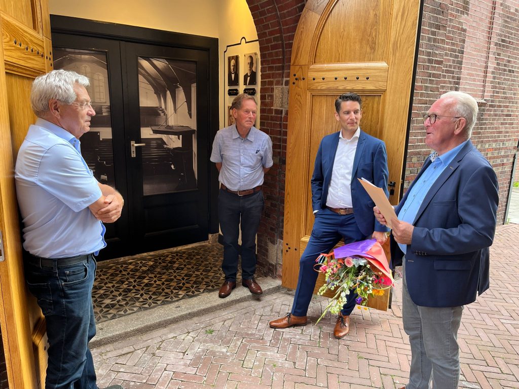 Uitreiking Erfgoedpluim 2023 aan de heer Jansen. Op de foto staan van links naar rechts de heer Jansen, de heer Slagman namens de Erfgoedadviesraad, wethouder Wessels en de heer Nijkamp namens de Erfgoedadviesraad.
