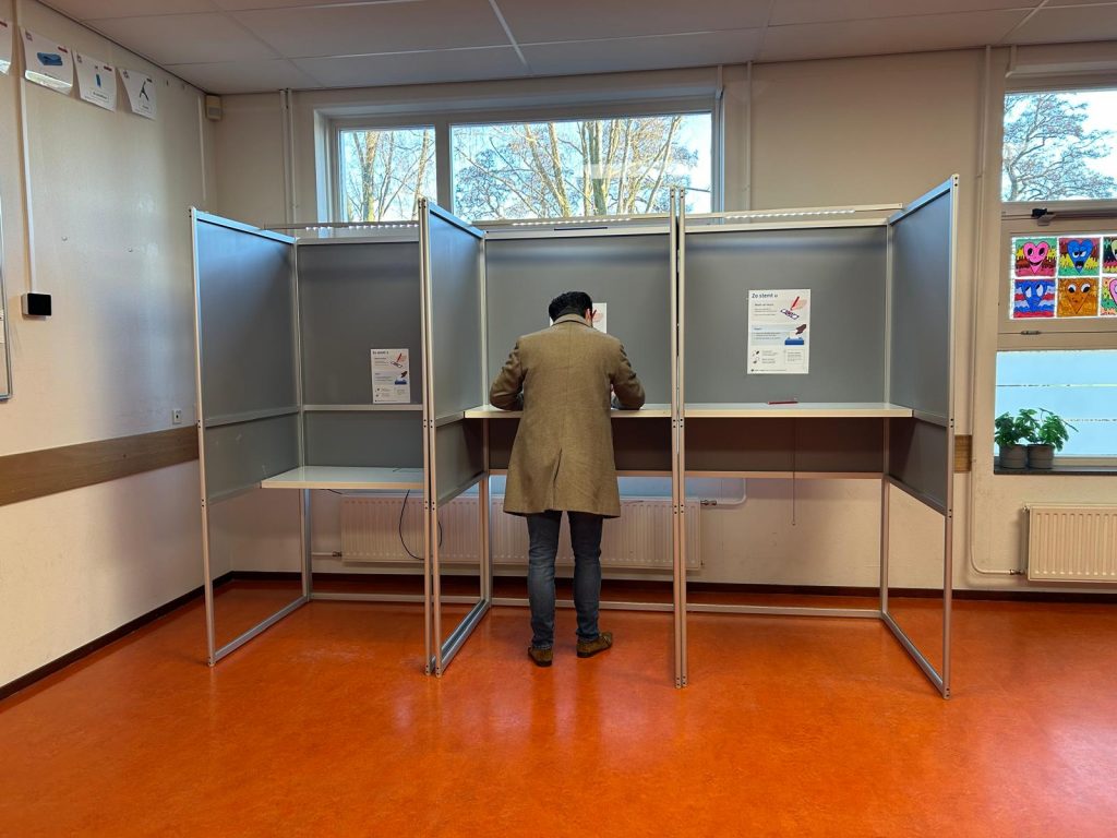 Foto van stemmer in stemhok